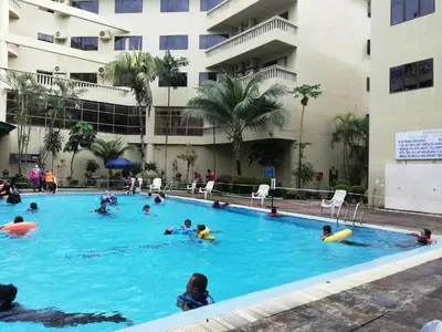 a group of people swimming in a swimming pool at 311 Pangkor Coral Bay Homestay in Pasir Bogak