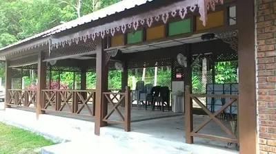 a pavilion with tables and chairs on a patio at D'Impiana Riverview Chalet # Lenggong in Kampong Ulu Jepai