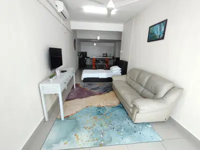a living room with a couch and a desk and a television at Homestay Studio Apartment Bentara Suite, Kompleks Mutiara Gua Musang in Gua Musang