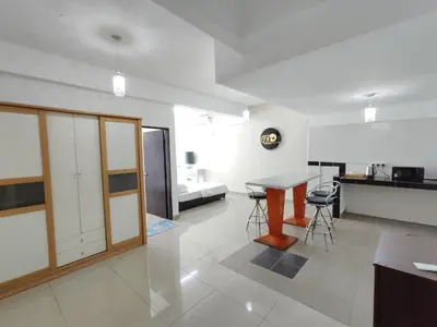 a kitchen and living room with a table and chairs at Homestay Studio Apartment Bentara Suite, Kompleks Mutiara Gua Musang in Gua Musang