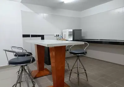 a kitchen with a counter with two bar stools at Homestay Studio Apartment Bentara Suite, Kompleks Mutiara Gua Musang in Gua Musang