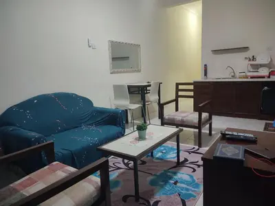 a living room with a blue couch and a table at Sofea Inn Bukit Merah - Laketown A6153 in Kampong Selemat
