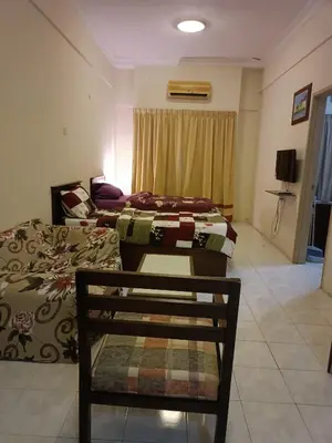 a room with two beds and a chair in it at Sofea Inn Bukit Merah - Laketown A6172 in Kampong Selemat