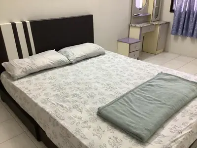 a bed with a green blanket on top of it at 4 Bedrooms Ipoh Landed House, Ipoh Town in Ipoh