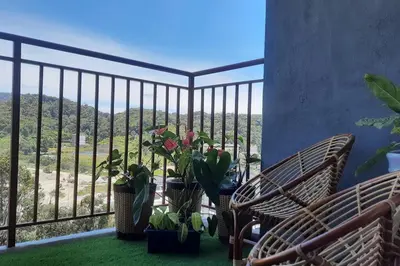 a balcony with chairs and potted plants and a view at Emerald Avenue Cozy 3R3B Apartment 830 in Brinchang