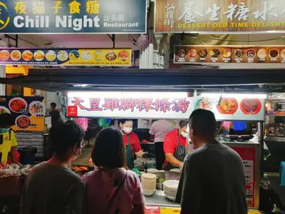 a group of people standing around a food truck at sungai ujong home stay in George Town