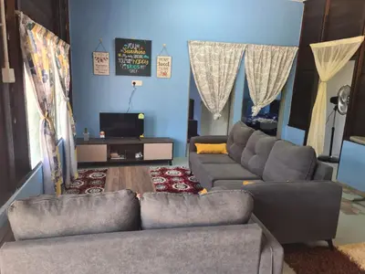 a living room with two couches and a tv at Teratak Desa Umaira in Tanjung Karang
