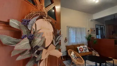 a living room with a wreath on the wall at G Residence - Cosy 4R3B Semi-D in Brinchang Town in Brinchang