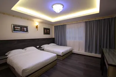 a hotel room with two beds and a window at Shamrock Guest House in Ipoh