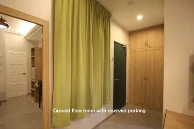 a room with a green curtain and a mirror at Shamrock Guest House in Ipoh