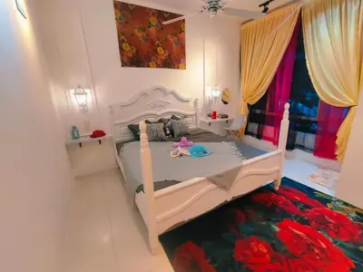 a bedroom with a white bed with a flower rug at SKGARDEN HOME A1 BY IRAINBOW in Ipoh