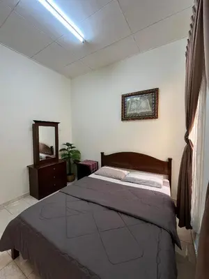 a bedroom with a bed and a dresser and a mirror at Rumah Tamu by Perdana Hōmes for Múslim only in Sungai Petani