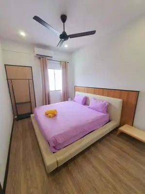 a bedroom with a bed with a purple blanket at (TS) Cozy House 4 Room10Pax@ALMA in Bukit Mertajam