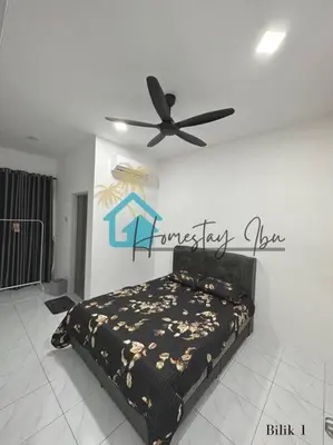 a bedroom with a bed and a ceiling fan at Homestay Ibu in Lumut
