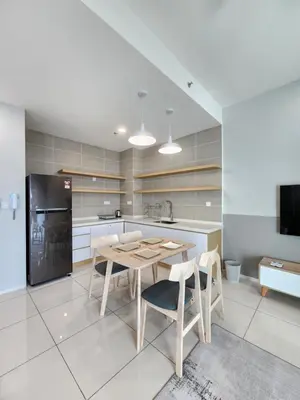 a kitchen with a table and chairs and a refrigerator at Sunway onsen suite ipoh in Ipoh