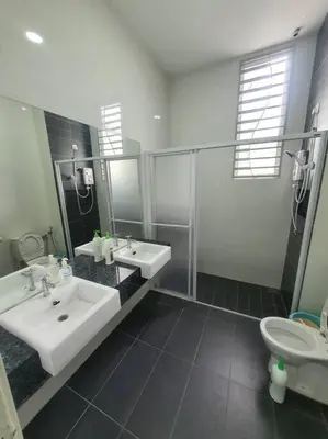 a bathroom with two sinks and a shower and a toilet at MODERN STYLISH 2STOREY HOUSE 8PAX@ALMA NEAR JUSCO in Bukit Mertajam