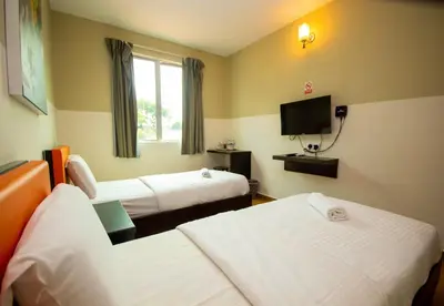a hotel room with two beds and a tv at JQ Suria Hotel in Lahat