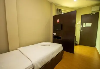 a small room with a bed and a television at JQ Suria Hotel in Lahat