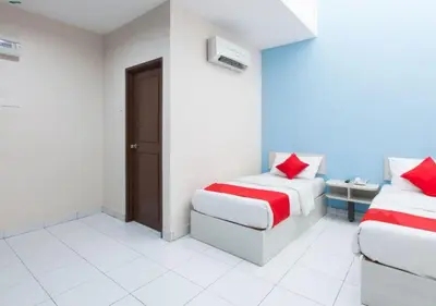 a room with two beds and a chair in it at Hotel Pulai Ipoh in Ipoh