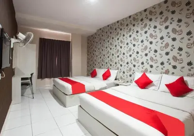 a hotel room with two beds with red pillows at Hotel Pulai Ipoh in Ipoh