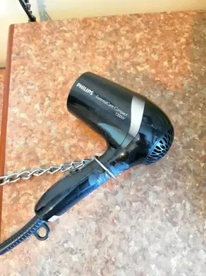 a hair dryer on a counter with a chain at Affordable Cozy Apartment @ Coral Bay Resort in Pasir Bogak