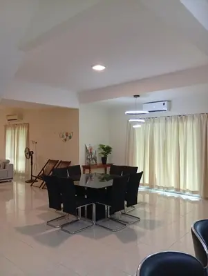 a living room with a table and black chairs at AnyLodge Waterfront Marina Island Pangkor-Lumut in Lumut