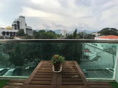 a potted plant sitting on a table on a balcony at 34zer0 Kinta Riverfront Suites 6pax in Ipoh