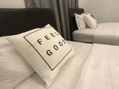 a bed with a pillow with the word tea on it at 34zer0 Kinta Riverfront Suites 6pax in Ipoh