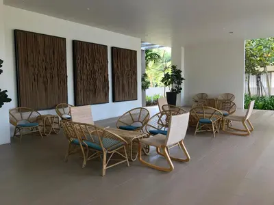 a group of chairs and tables in a room at By The Sea Luxury Beachfront Resort 223 in Batu Ferringhi