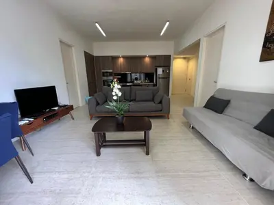 a living room with two couches and a coffee table at By The Sea Ground Floor with Pool Facing 3A in Batu Ferringhi