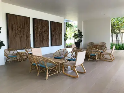 a group of wicker chairs and tables on a patio at By The Sea Ground Floor with Pool Facing 3A in Batu Ferringhi