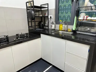 a kitchen with white cabinets and black counter tops at Spacious 3BR I Meritus Perai l Family & Nice View in Perai