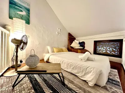 a bedroom with a bed and a table in it at Le Meilleur in George Town