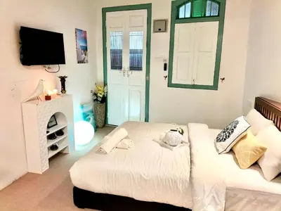 a bedroom with a bed and a tv and a window at Le Meilleur in George Town