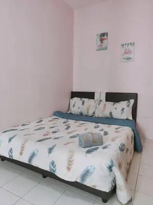 a bed in a bedroom with a white wall at FZHomestays in Cameron Highlands in Cameron Highlands