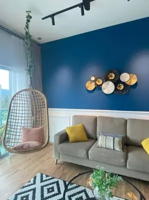 a living room with a couch and a blue wall at Sunrise Terrace at Quintet (3BR/8 pax) in Tanah Rata