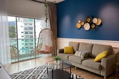 a living room with a couch and a blue wall at Sunrise Terrace at Quintet (3BR/8 pax) in Tanah Rata
