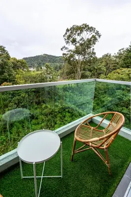 a rattan chair and a table on a balcony at Green Terrace at Quintet (3BR/ 8 Pax） in Tanah Rata