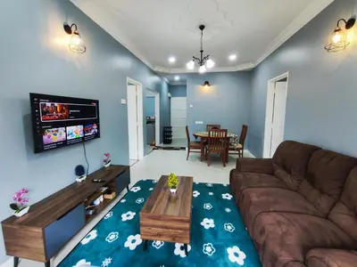 a living room with a couch and a table at A One Holiday Apartment - PRO in Tanah Rata