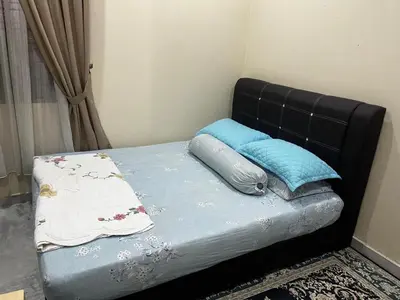 a bed with a black headboard and two pillows at Homestay Hajrah in Ipoh
