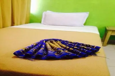 a bed with a blue and gold blanket on it at F Hotel Bayan Lepas in Bayan Lepas