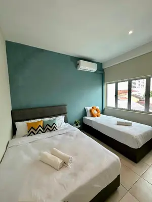 a bedroom with two beds and a teddy bear sitting on top at Swing & Pillows - Penang Road, Georgetown Penang in George Town
