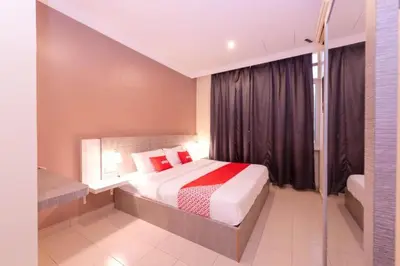 a bedroom with a bed with red pillows at Spring Inn Hotel in Sungai Petani