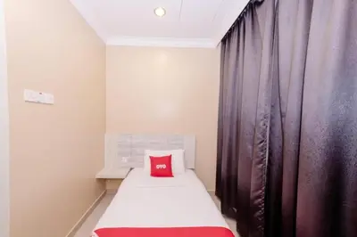 a small bedroom with a red pillow on a bed at Spring Inn Hotel in Sungai Petani