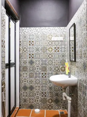 a bathroom with a sink and a tiled wall at Carnarvon Antique Loft in George Town