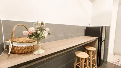 a counter with a basket of flowers and two stools at Ipoh The Cove Hillside Stay 7 to 10 pax, 5 min to Ipoh Town in Ipoh