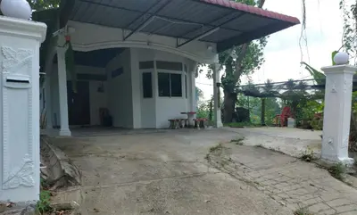 a white house with awning and a bench in front of it at SEROJA HOMESTAY in Baling