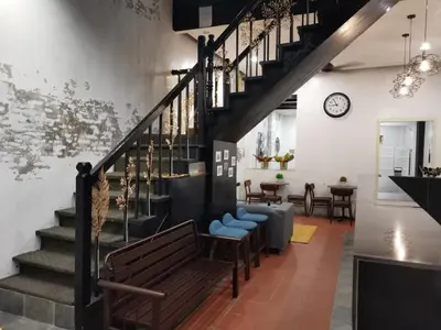 a living room with a staircase and a bench at G FORTUNE GUEST HOUSE+ in George Town
