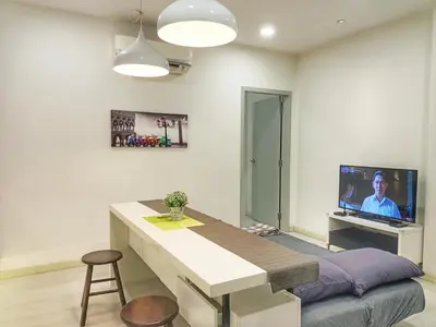 a kitchen with a table and a tv in a room at Deluxe suites 3, 1BR, 2-5 pax, Netflix, Georgetown in George Town