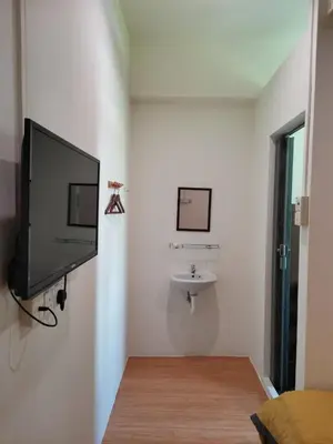 a living room with a flat screen tv and a sink at G FORTUNE HOTEL + in George Town